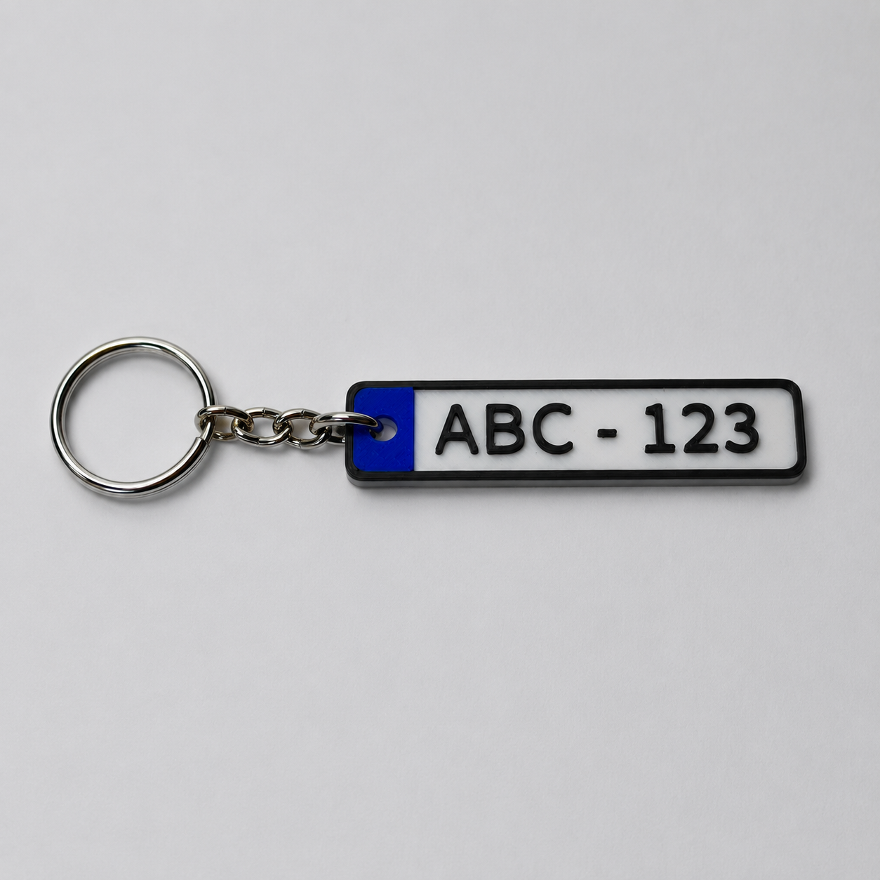 Valkoinen rekisterikilpiavaimenperä tekstillä ABC-123
